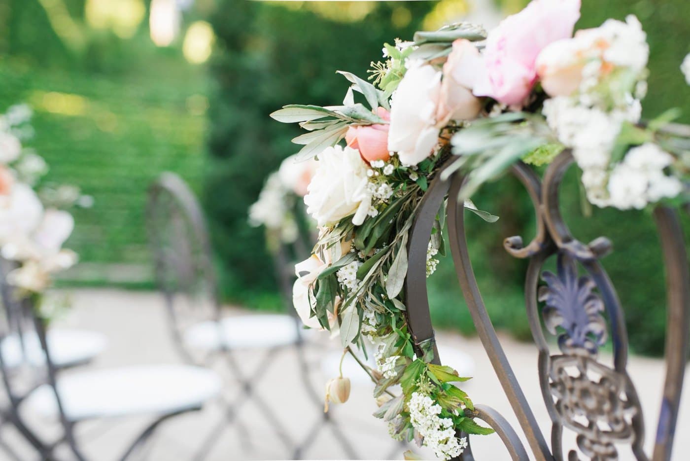 Ceremony chairs dressed with garden roses and olive